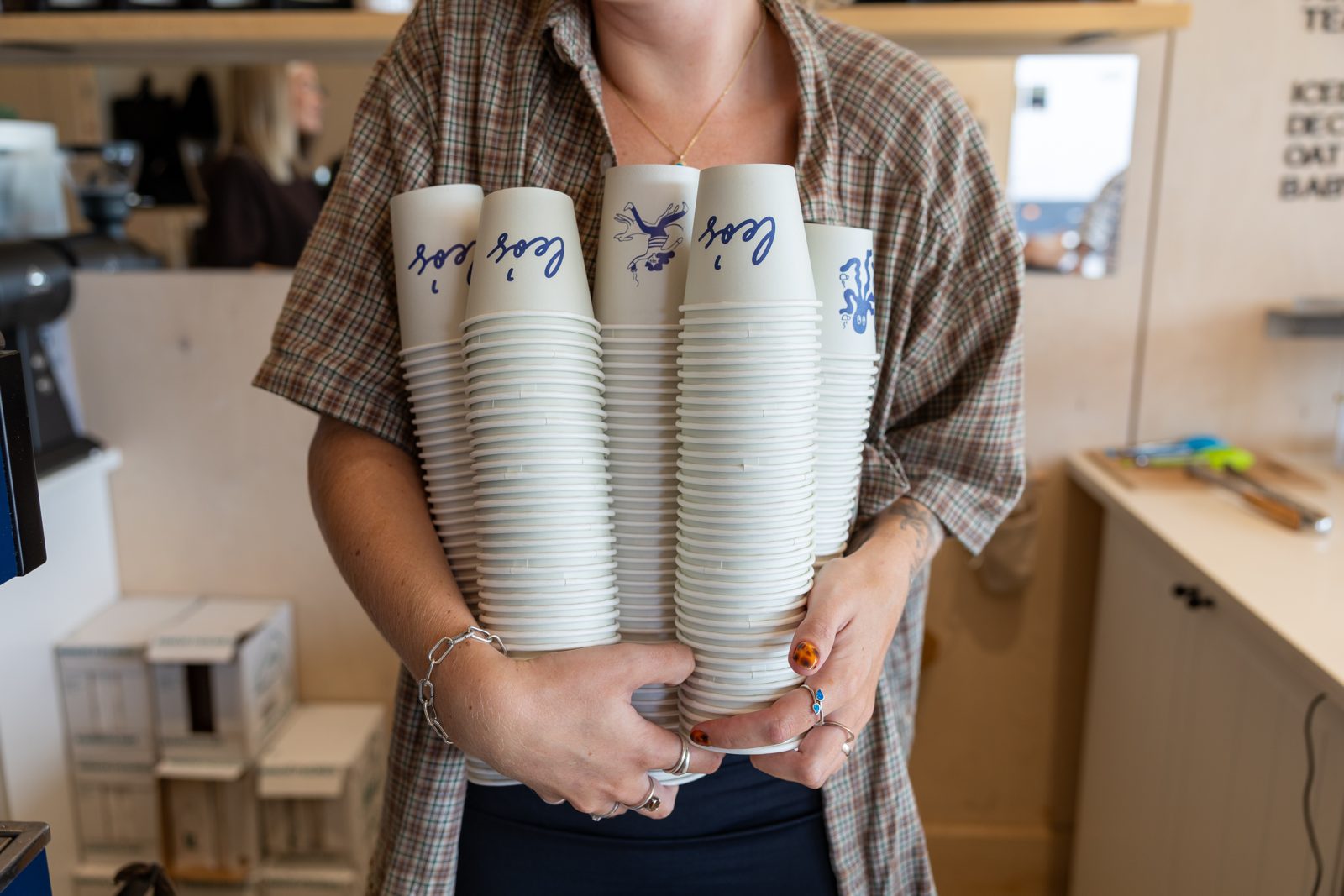A Leo's barista carrying stacks of Leo's cups